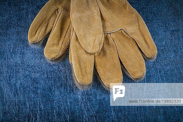 Close up Bild von Leder braunen Schutzhandschuhe auf zerkratzt metallischen Oberfläche Gebäude Konzept