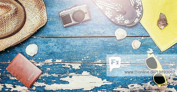 Sommerlicher Hintergrund: Konzept der Freizeitreise im Sommer: Strohhut  Sonnenbrille  Muscheln  VintageKamera Reisepass und Flip Flops. Kopierraum