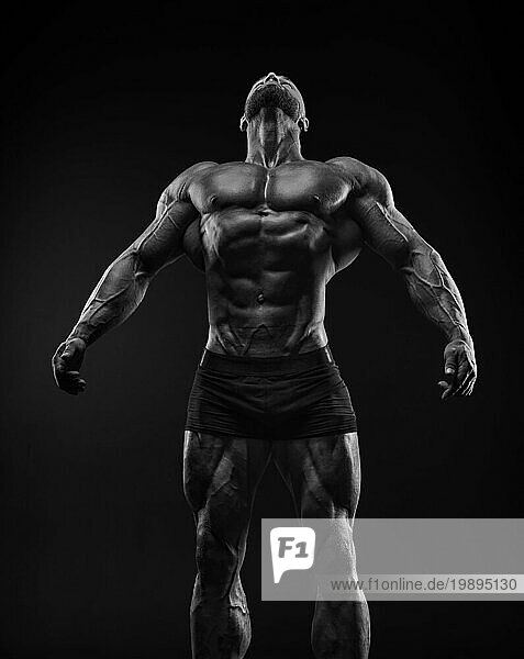 Silhouette eines starken Bodybuilders. Selbstbewusster junger Fitness Sportler mit einem kräftigen Körper und perfekten Bauchmuskeln. Schwarz Weiß Fotografie. Dramatisches Licht. Gemischte Medien