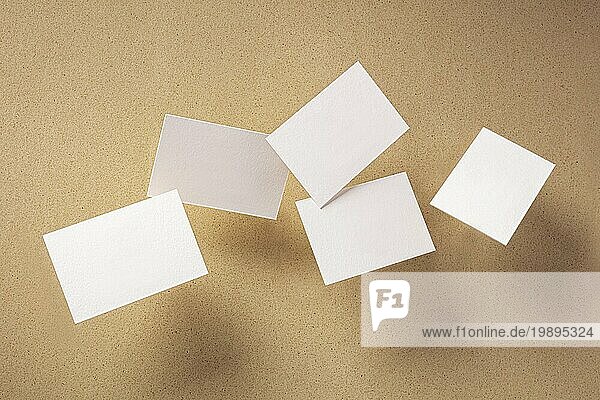 Weiße dicke Visitenkarten  die auf einem braunen Papierhintergrund fliegen  eine Vorlage für eine kreative Designpräsentation