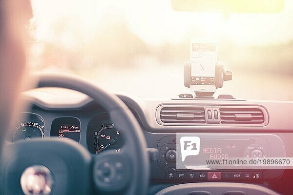 Armaturenbrett eines Autos mit Smartphone als Navigationsgerät  heller und sonniger Tag