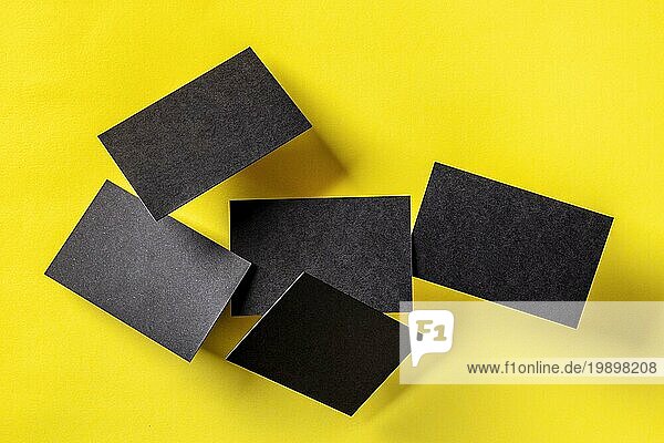 Dicke schwarze Visitenkarten  schwebend auf einem gelben Papier Hintergrund  ein Mockup für eine kreative Designpräsentation