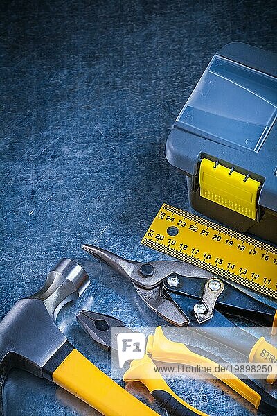 Scratched Vintage metallischen Hintergrund mit Werkzeugkasten Klaue Hammer Lineal Zange und Zinn Schere Baukonzept