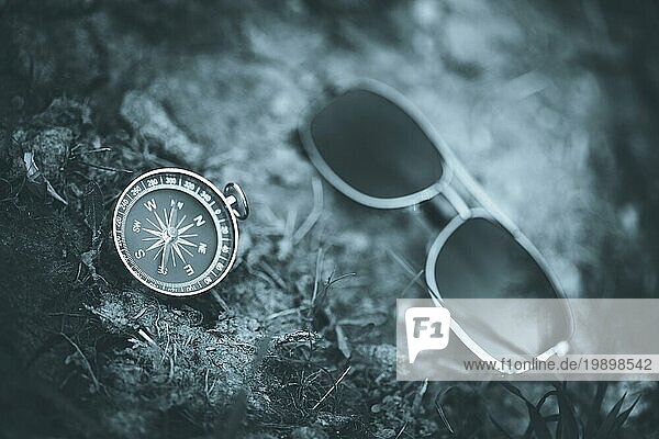 Vintage Kompass und Sonnenbrille auf dem Boden liegend. Abenteuer und Entdeckung Konzept