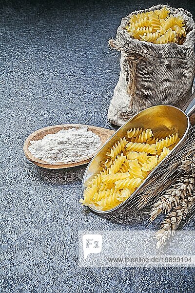 Sack Sack ungekochte Nudeln Küche Schaufel Holzlöffel Mehl Weizen Roggen Ohren auf schwarzem Hintergrund