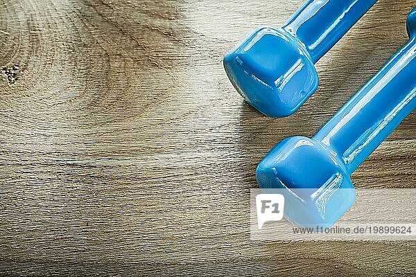 Blaue Hantel Gewichte auf Holzbrett Fitnesskonzept