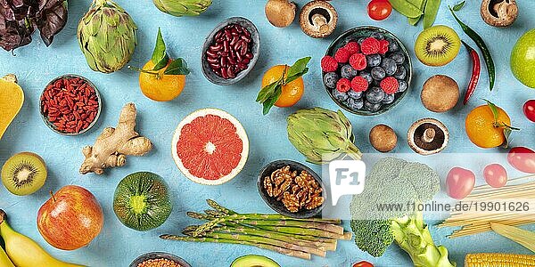 Veganes Lebensmittel Panorama. Gesunde Ernährung Konzept. Obst  Gemüse  Nüsse  Hülsenfrüchte  Pilze  Schuss von oben auf einem blaün Hintergrund  ein Flatlay