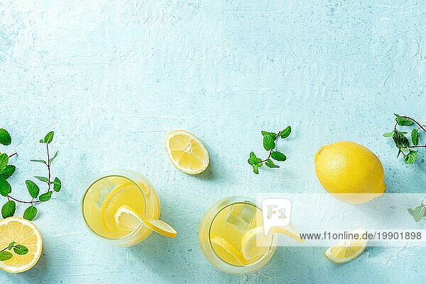 Limonade. Hausgemachter frischer Zitroneneistee  Aufnahme von oben mit Kopierraum auf blauem Hintergrund. Ein gesundes Entgiftungs Kaltgetränk