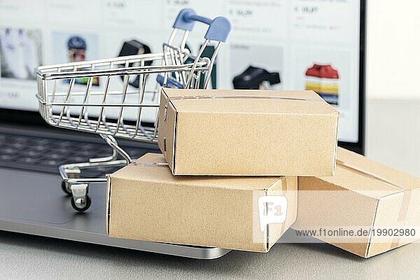 Online Shopping Konzept. Online Web Shop Kauf. Kartons und Einkaufswagen auf Laptop