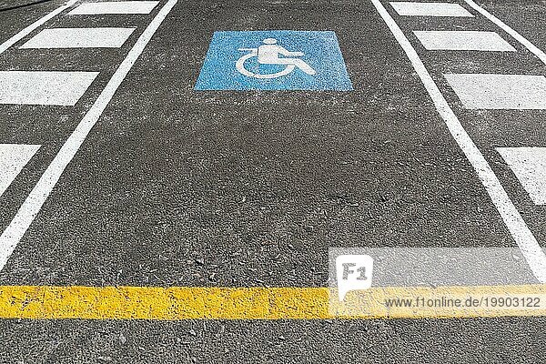 Parkplatz für Rollstuhlfahrer im Freien. Verkehrszeichen Behindertensymbol auf Asphalt gemalt