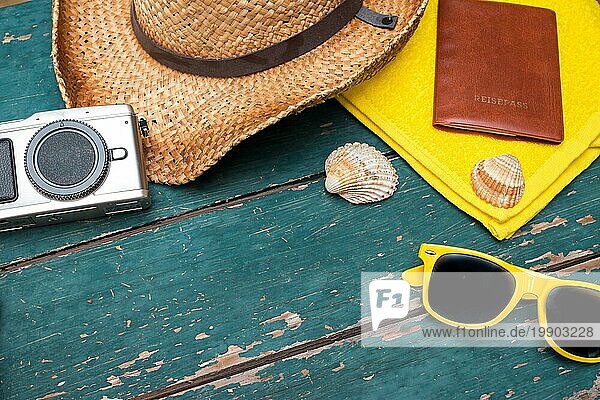 Sommerlicher Hintergrund: Konzept der Freizeitreise im Sommer: Strohhut  Sonnenbrille  Flip Flops  Muscheln  VintageKamera Handtuch und Reisepass