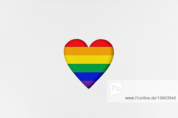 Herzform mit neu gestalteter LGBTQ Stolzflagge auf weißem Karton. Bedruckter Karton mit ausgestanzter Herzform. Ansicht von oben