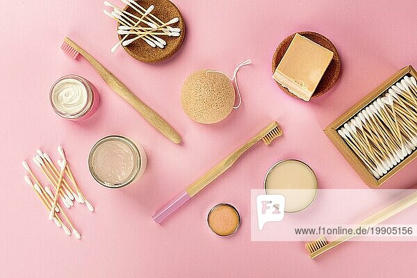 Plastikfreie  abfallfreie Kosmetika  flachgelegt auf rosa Hintergrund. Zahnbürsten und Wattestäbchen aus Bambus  Konjac Schwamm  natürliche Bio Produkte