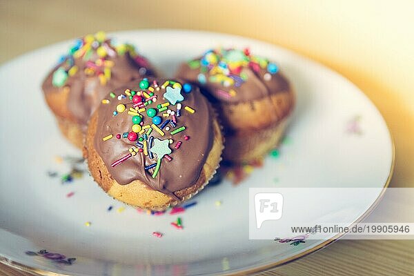 Hausgemachte süße Cupcakes auf einem Teller mit bunter Dekoration
