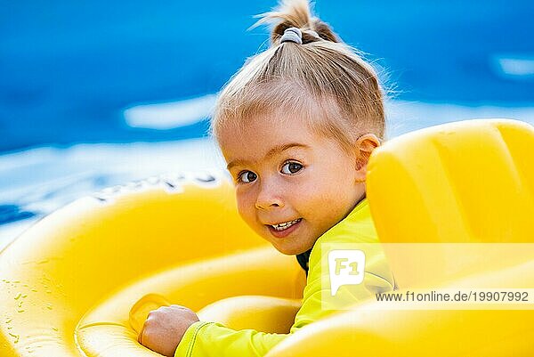 Kind im Schwimmbad in gelben aufblasbaren Taille Baby Swim Float am Sommertag zu schwimmen. Kinder im Schwimmbad safty Konzept