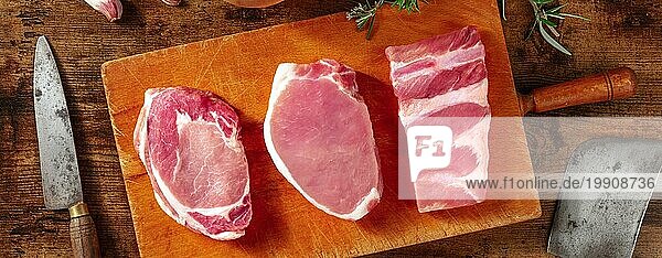 Schweinefleisch Panorama auf einem rustikalen Holztisch  mit Messern