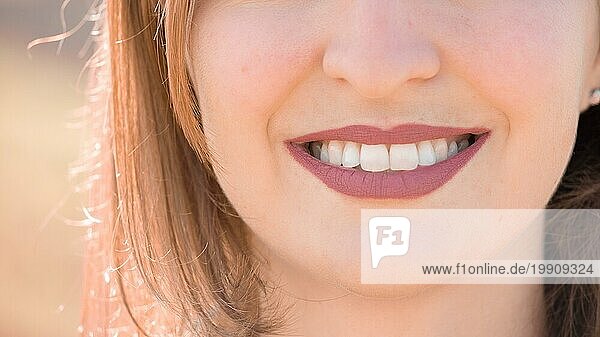 Schönes Mädchen mit kirschroten Lippen und weißen Zähnen lächelt
