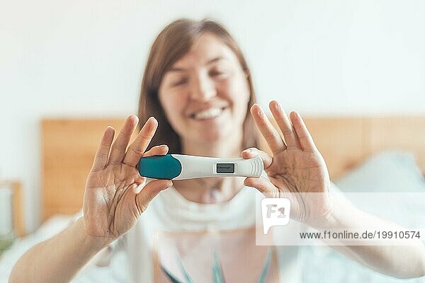 Glückliche Mutter hält Schwangerschaftstest in den Händen  Ergebnis ist schwanger  ?Schwanger?