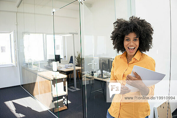 Businesswoman with mouth open holding document at office