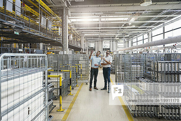 Inspector examining factory floor with colleague at industry