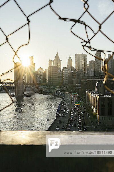 Urban skyline from Manhattan bridge at sunset in New York City