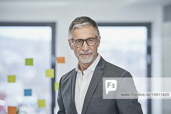 Smiling senior businessman wearing eyeglasses in office