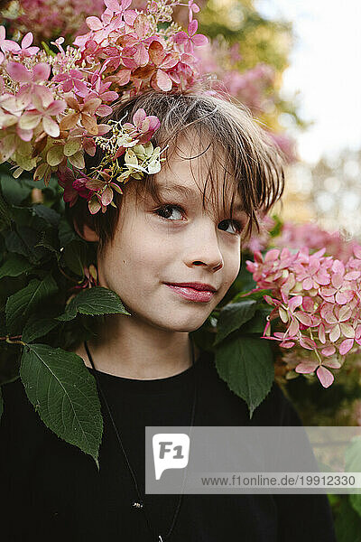 Thoughtful boy amidst hydrangea flowers