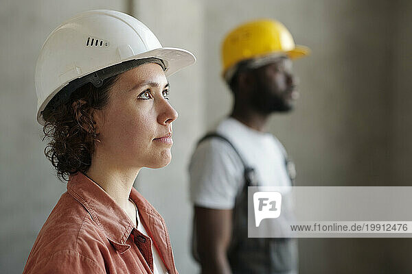 Engineer wearing hardhat with coworker in background