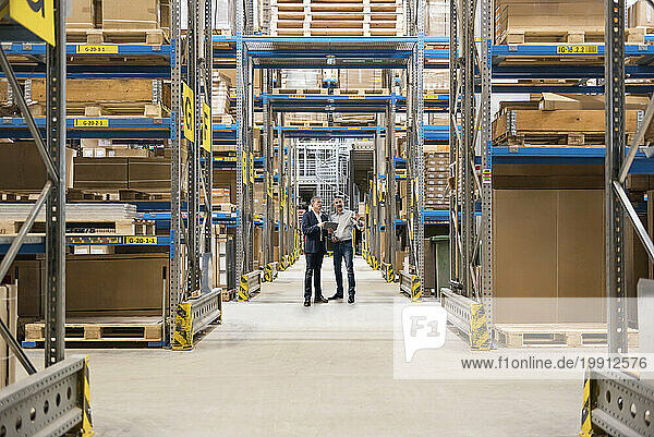 Businessmen standing and planning in warehouse