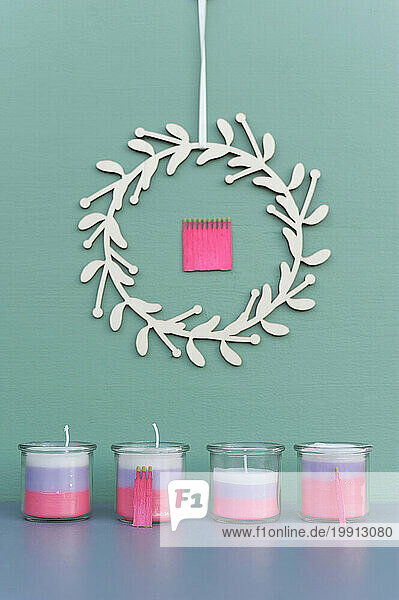 Studio shot of Advent wreath and decorative candles in glass jars