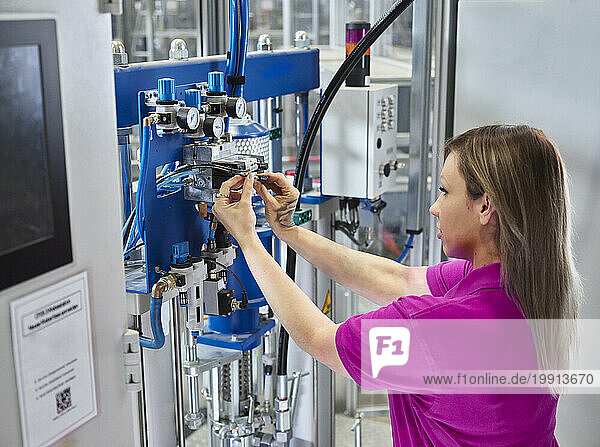 Technician adjusting compressed air manifolds on machine