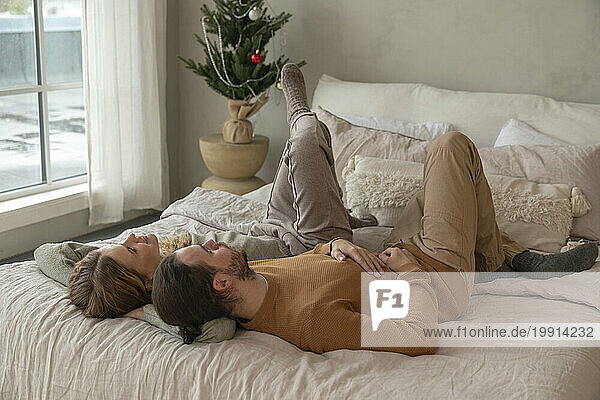 Couple lying together on bed at home
