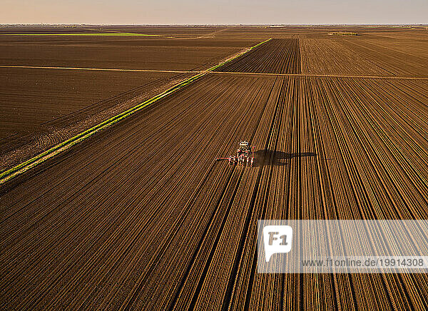 Serbia  Vojvodina Province  Aerial view of tractor sowing seeds in plowed corn field