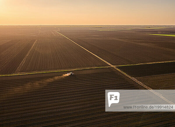 Serbia  Vojvodina Province  Aerial view of tractor sowing seeds at dusk