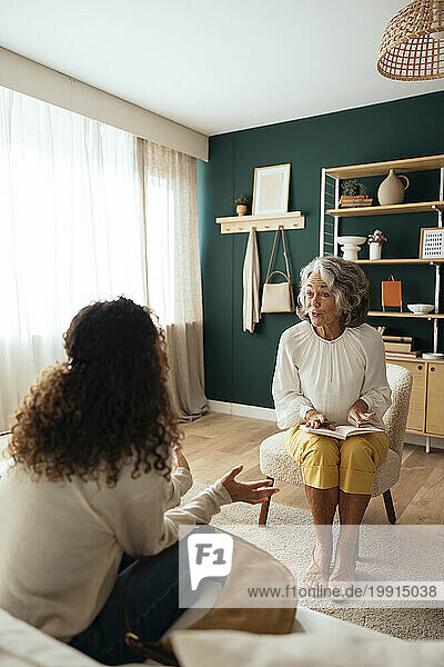 Mature psychologist counseling patient at home