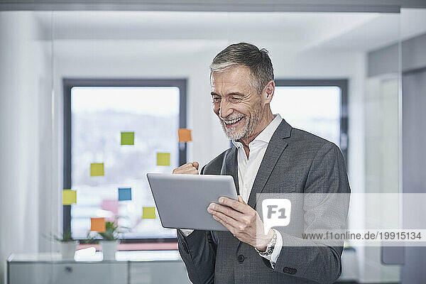 Successful senior businessman using tablet PC in office