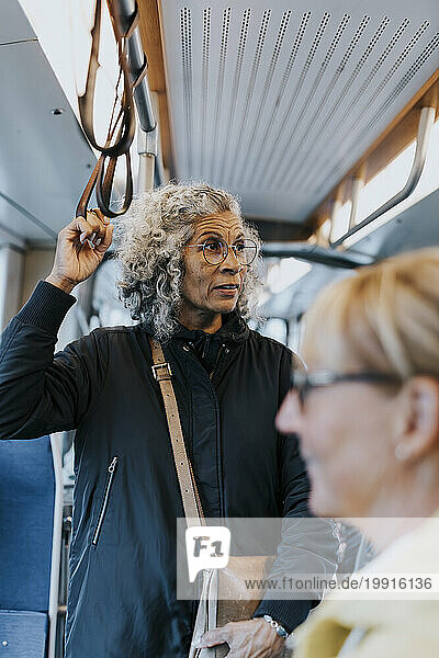 Contemplative female entrepreneur looking away while commuting through bus