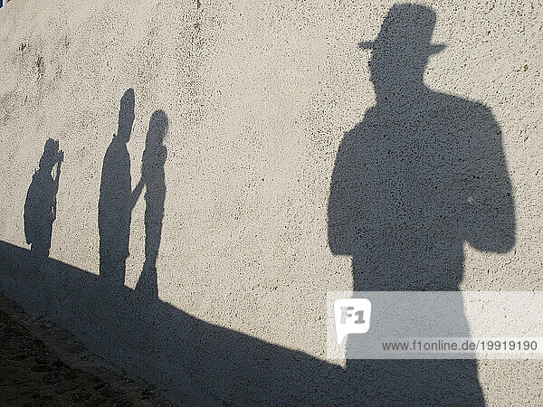 Shadows of tourists as they walk/photograph in Fira  Santorini  Greece
