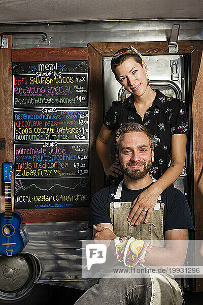 The Silver Seed food trailer which serves Vegan food only. Owners and married couple  Taylor Smith (dude)  and Melanie Boyna (lady) holding a Shredded Squash Taco.