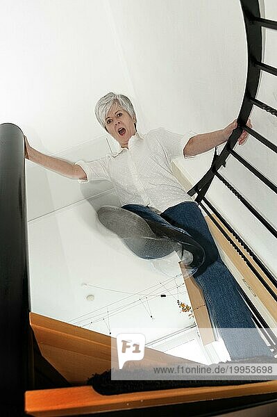 Frau steht auf einer Treppe und tritt mit dem Fuß nach unten Richtung Betrachter