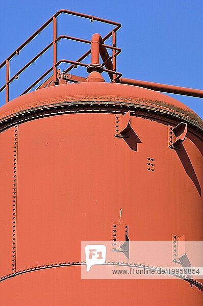 Großer Industrietank mit Nietenreihen und rotbrauner Farbe
