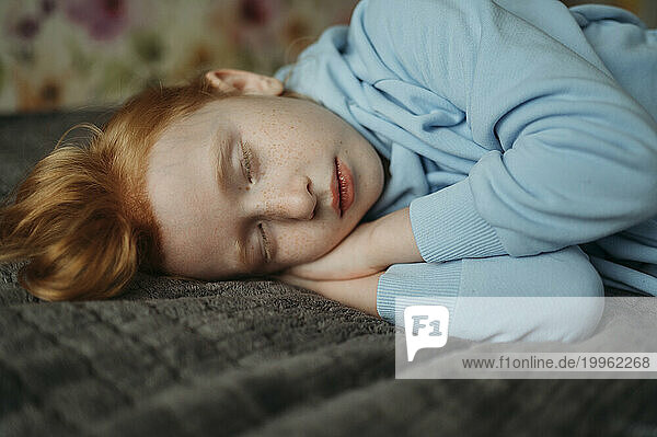 Redhead girl sleeping on bed