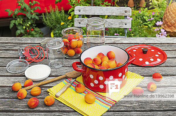 Preparation of apricot preserves on wooden garden table