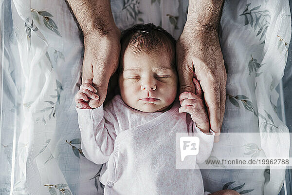 Father holding baby girl's hands