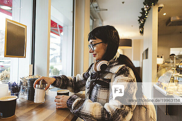Woman having coffee standing in cafe