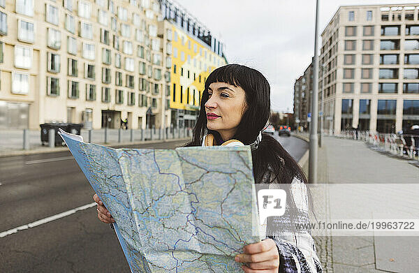 Woman with map exploring city on weekend