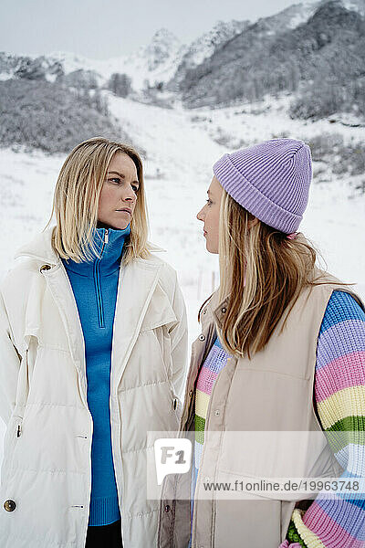 Blond woman looking at friend on snowscapped mountain