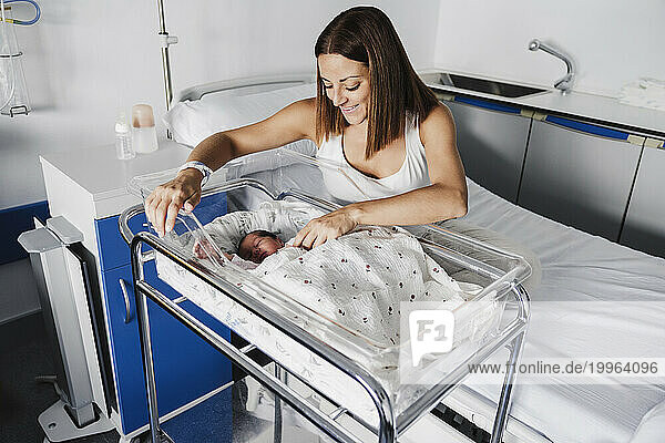 Happy mother with baby daughter in hospital bed