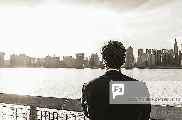 Businessman looking at city view by Hudson River  New York City  USA