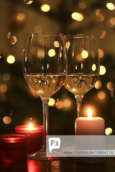 Burning candles and two glasses of white wine